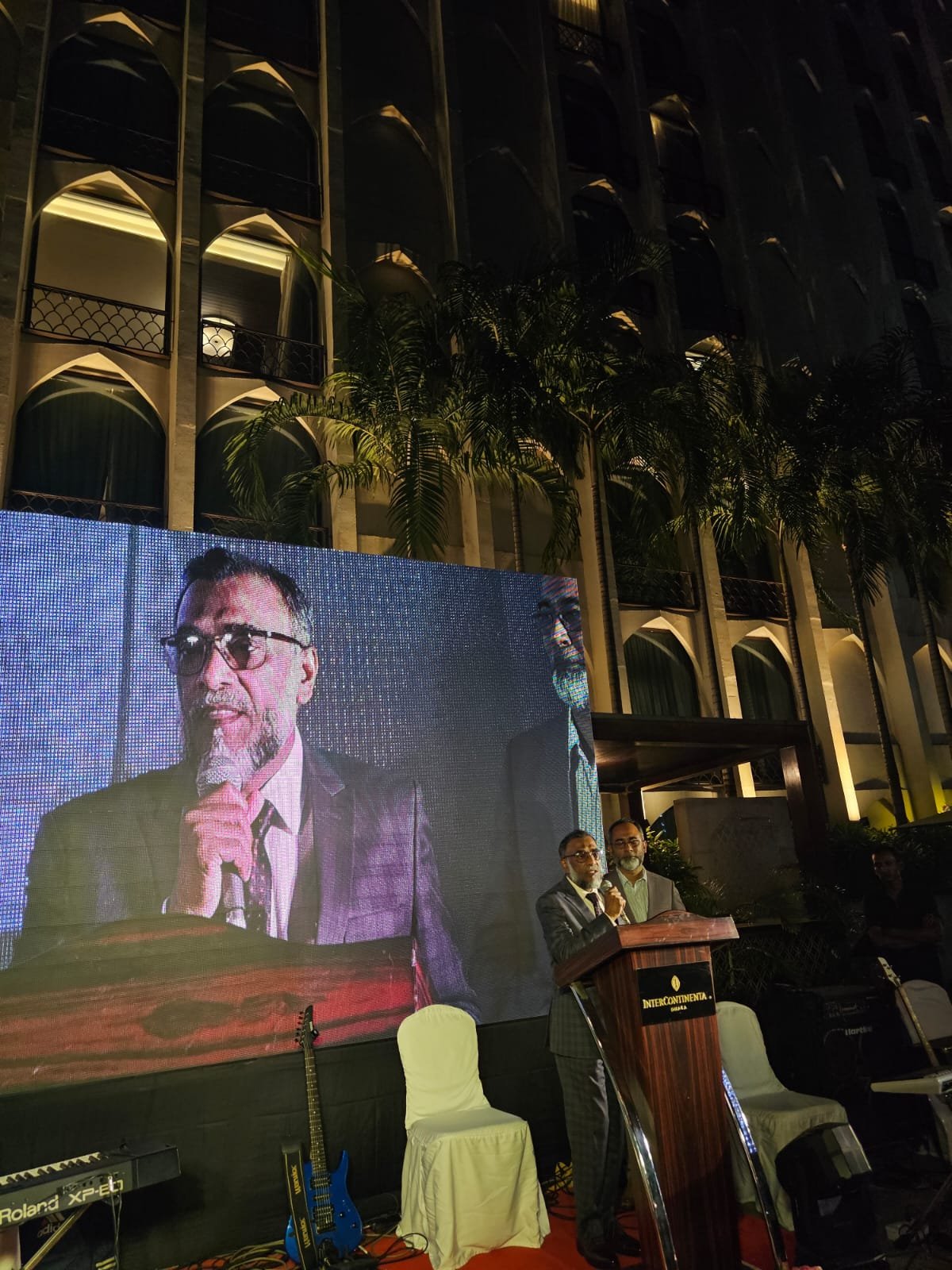 Speaker on stage with live projection